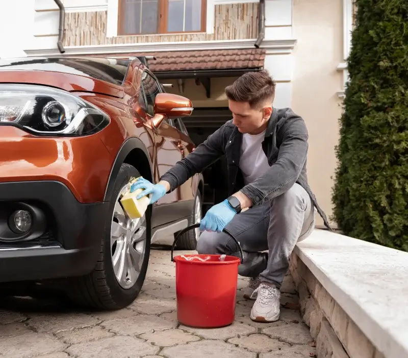 Lavage auto à domicile Rhèges : professionnel intervenant sur un véhicule
